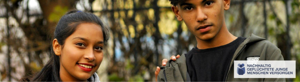 Zwei Jugendliche, eine junge Frau und ein junger Mann, stehen nebeneinander im Freien und blicken freundlich in die Kamera.